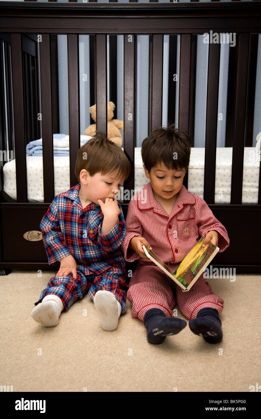 Zwei Brüder, ein Buch zu lesen, vor dem Schlafengehen, 20 Monate alt und drei Jahre alt Stockfoto