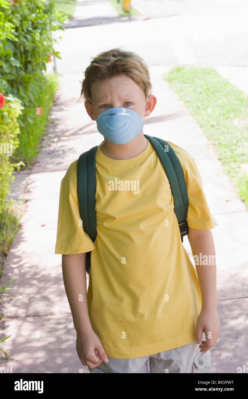 Kleinen Jungen gehen zur Schule tragen eine Gesichtsmaske Stockfoto
