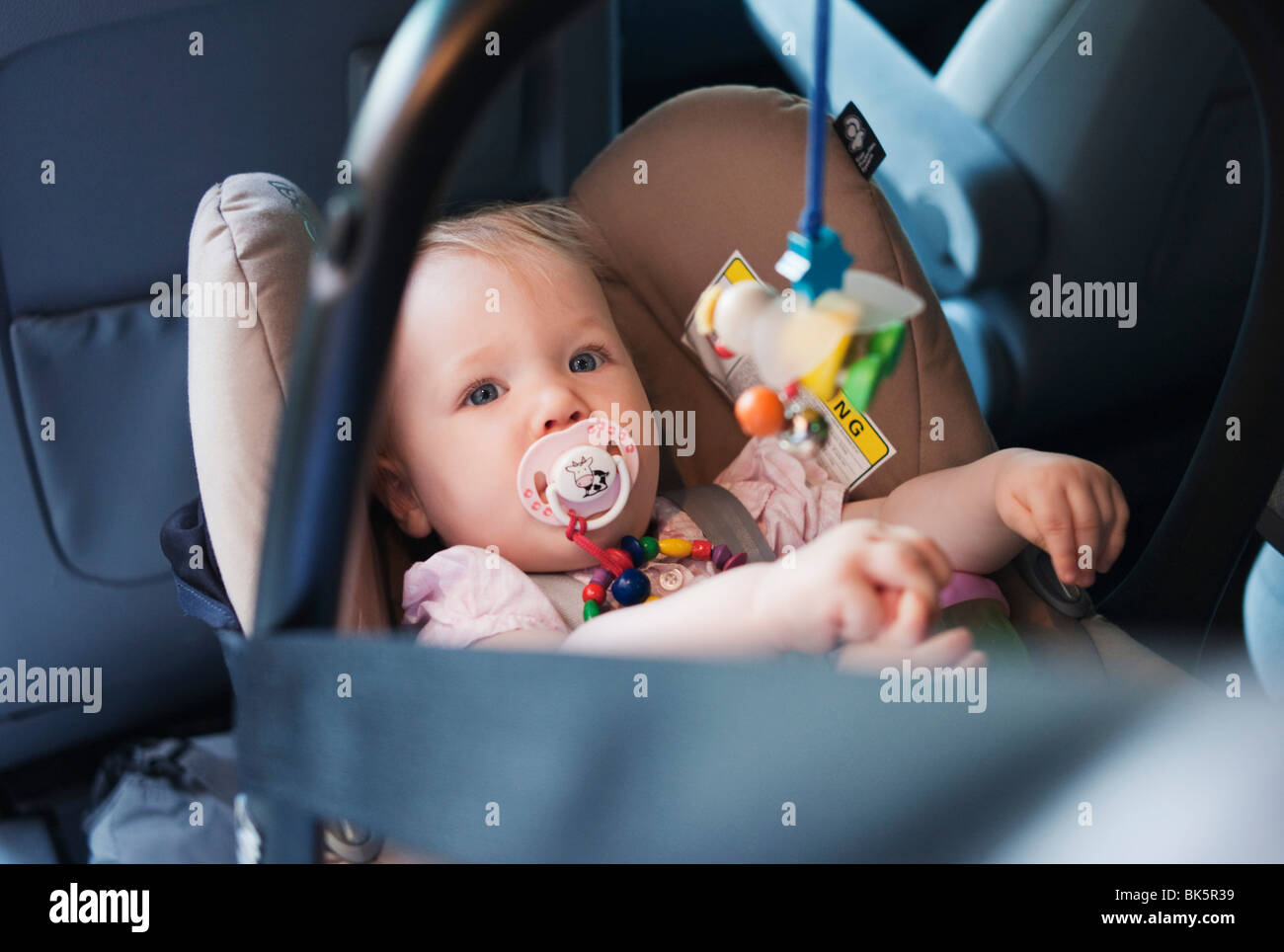 Babymädchen in Autositz Stockfoto