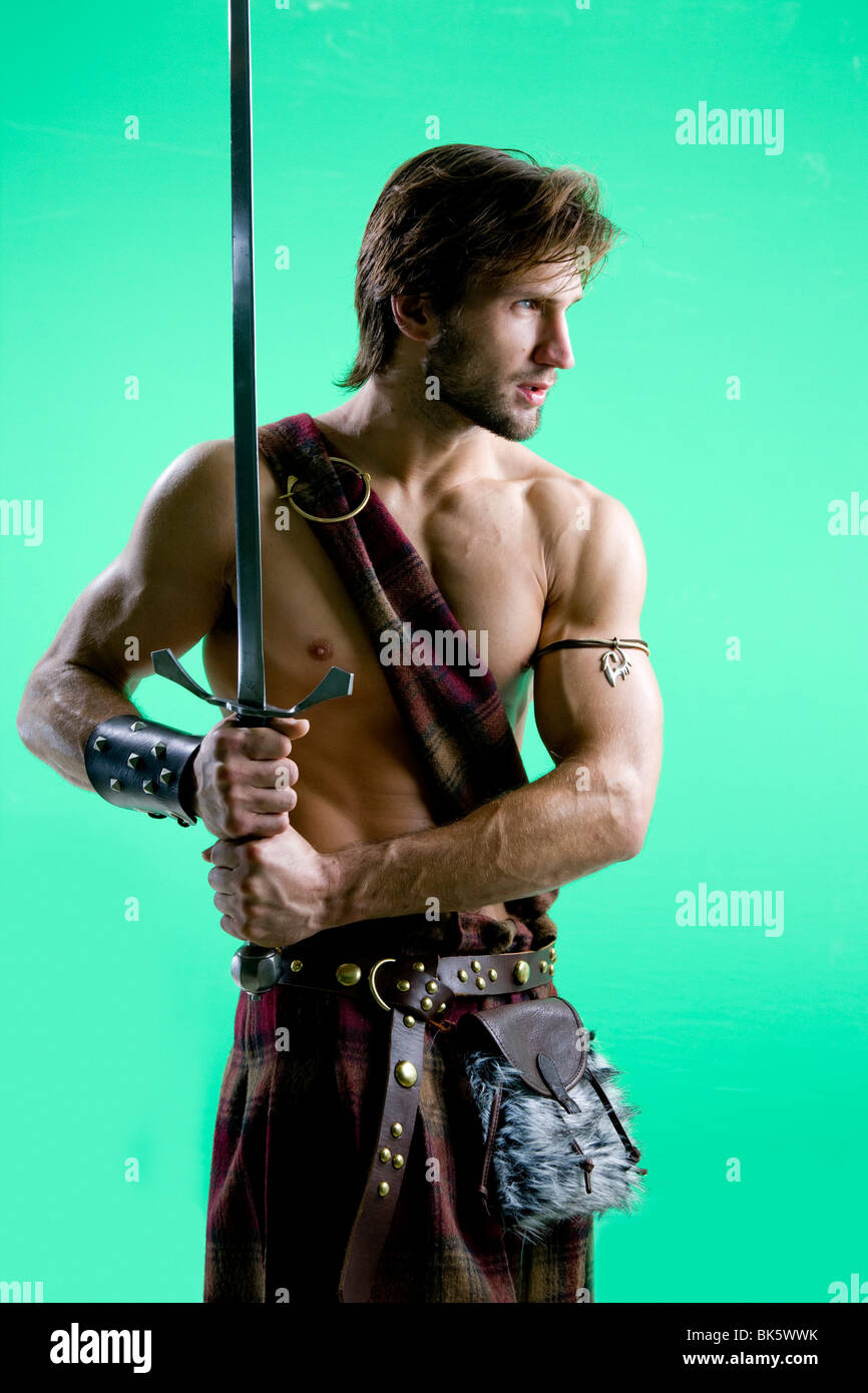 Junger Mann in Krieger Kostüm mit einem Schwert Stockfoto