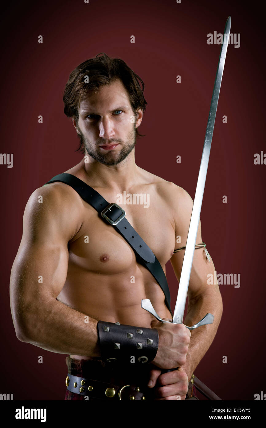 Junger Mann in Krieger Kostüm mit einem Schwert Stockfoto