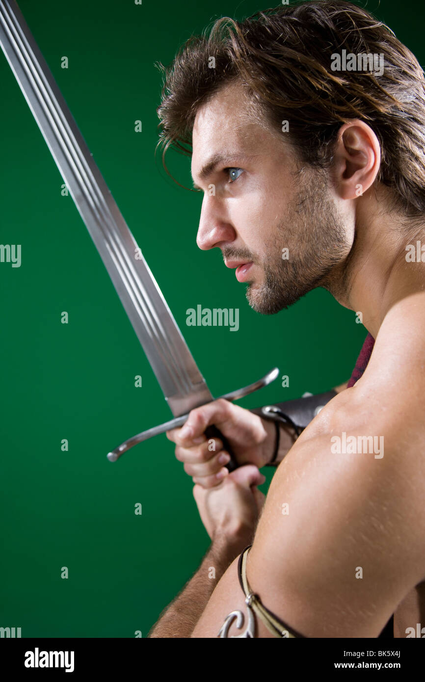 Junger Mann in Krieger Kostüm mit einem Schwert Stockfoto