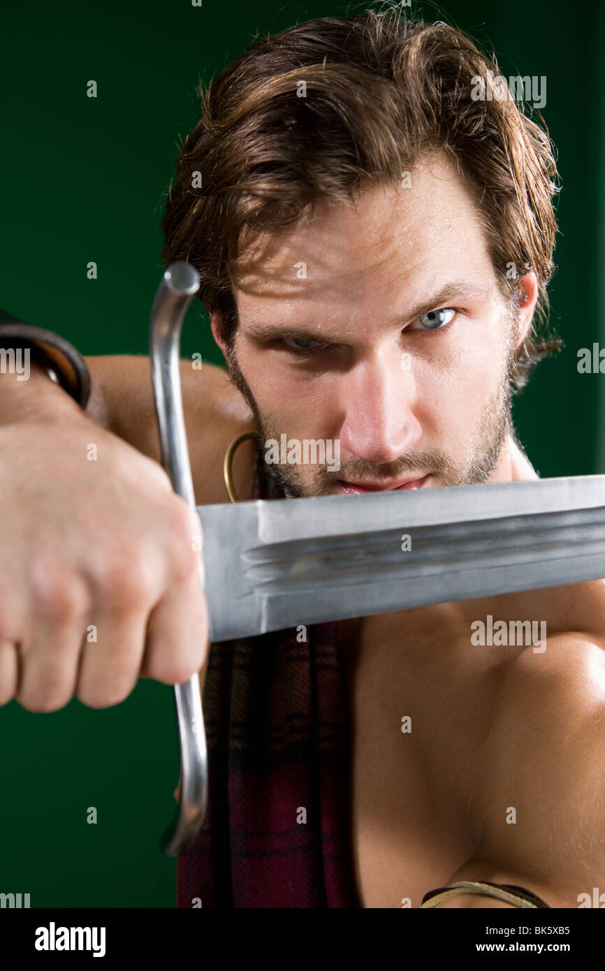 Junger Mann in Krieger Kostüm mit einem Schwert Stockfoto