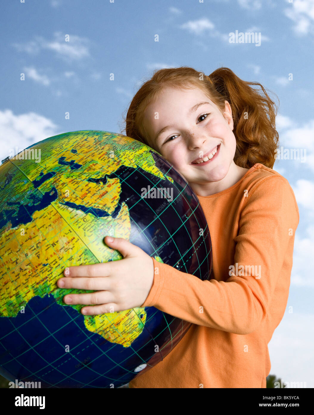 Mädchen hält einen Globus und lächelnd Stockfoto