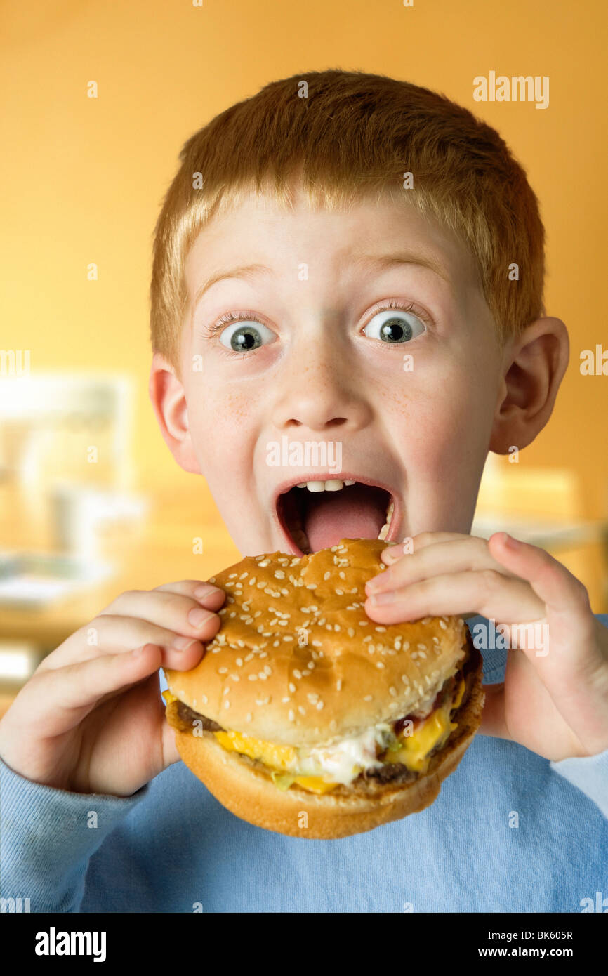 Junge, einen Hamburger Essen Stockfoto