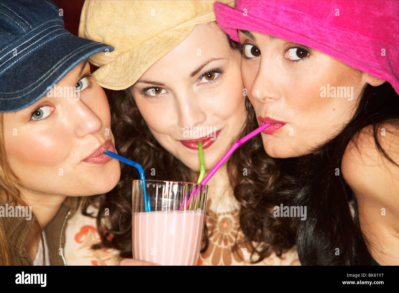 Porträt von drei jungen Frauen trinken smoothie Stockfoto
