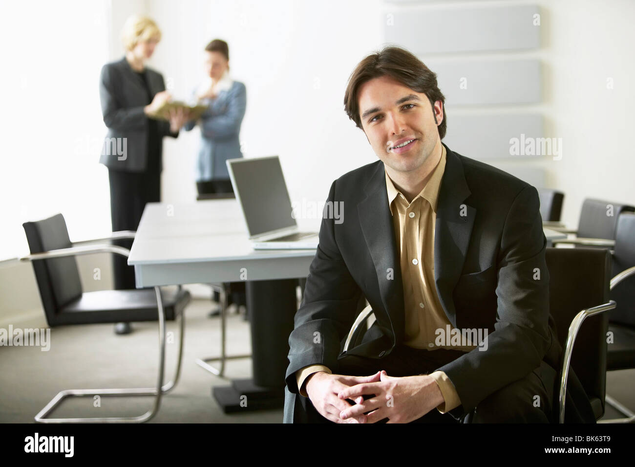 Porträt eines Geschäftsmannes lächelnd mit seinem Kollegen im Hintergrund arbeiten Stockfoto