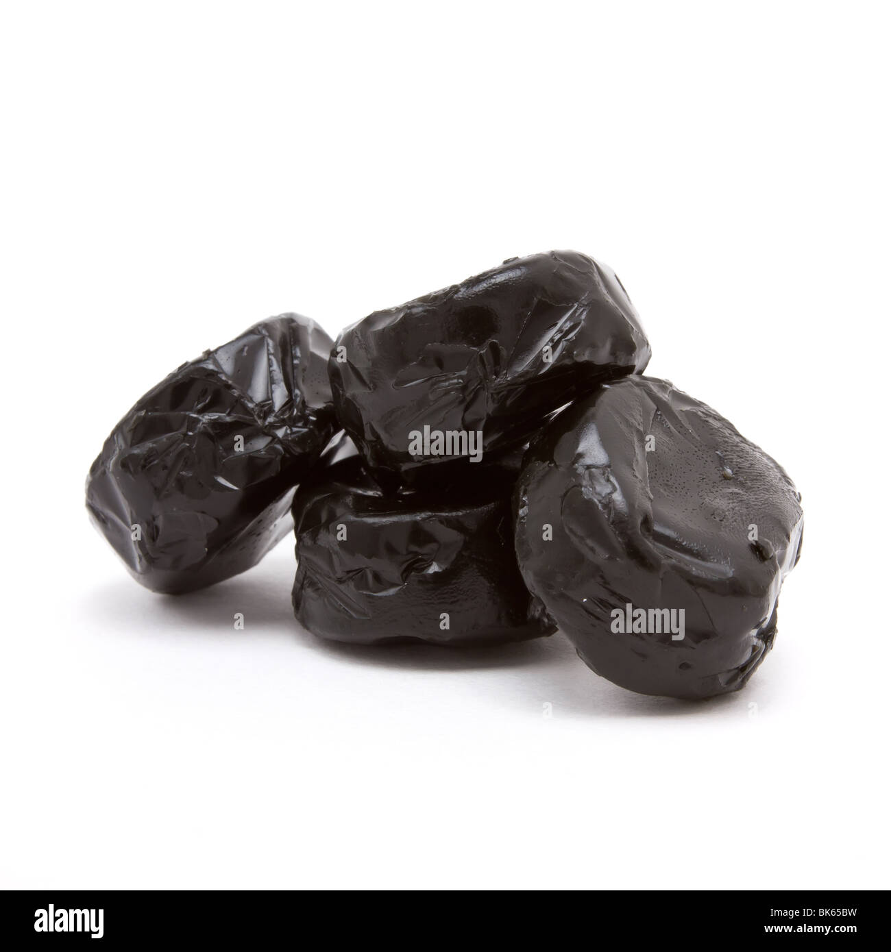 Schwarz glänzenden Lakritz Toffee isoliert vor weißem Hintergrund. Stockfoto