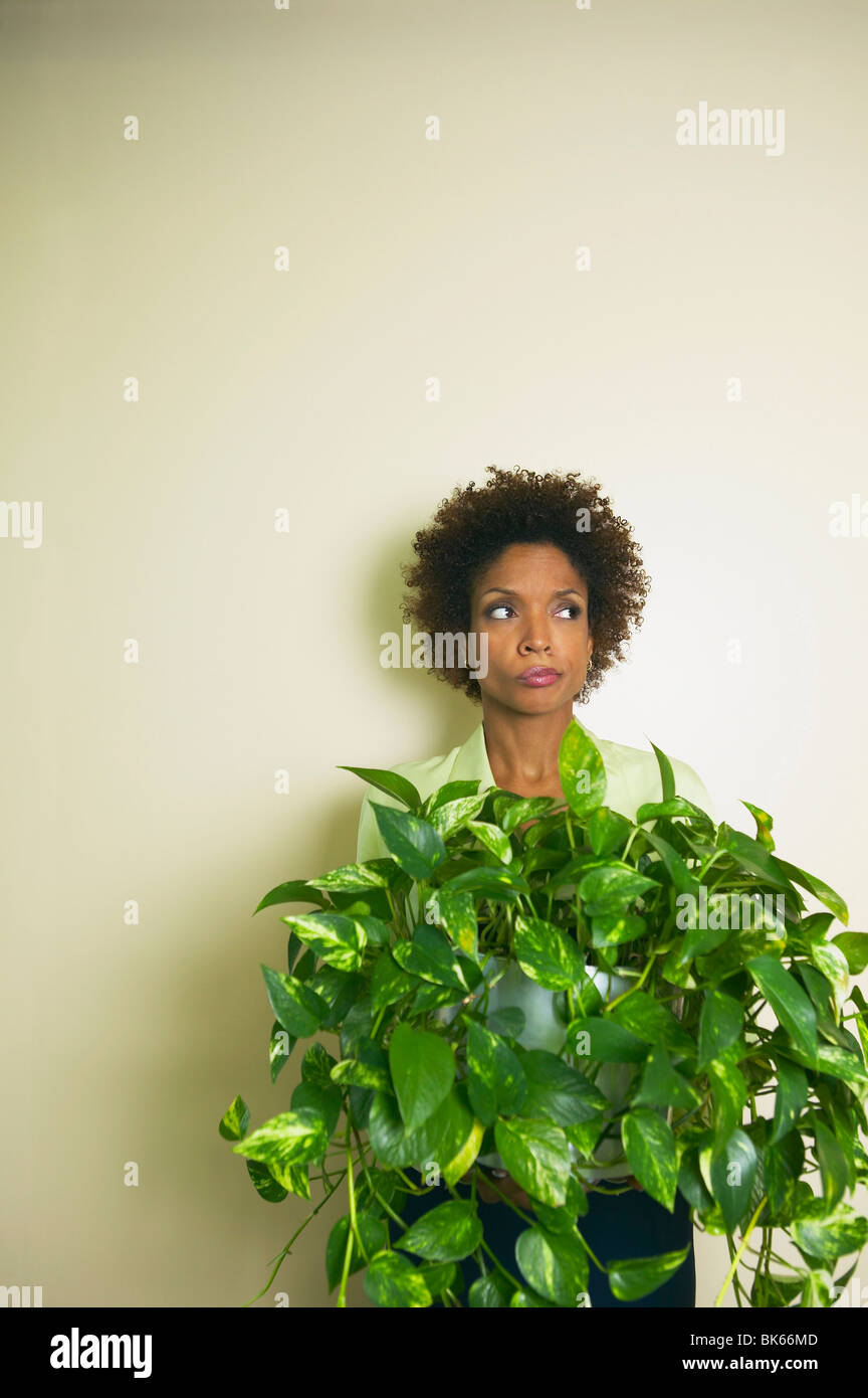 Geschäftsfrau hält eine Büro-Pflanze Stockfoto