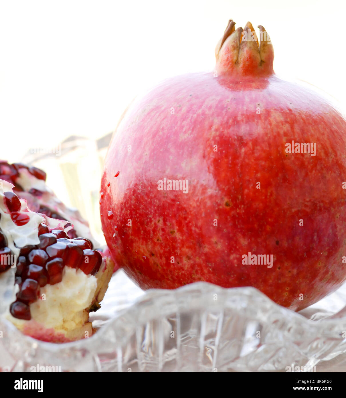ganz rote Reife Granatapfel mit einer offenen Granatapfel zeigt die Samen Stockfoto