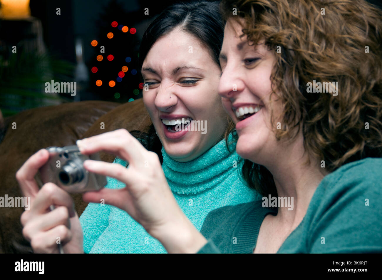 Zwei Frauen betrachten Bilder mit einer Digitalkamera und lachen zusammen. Stockfoto