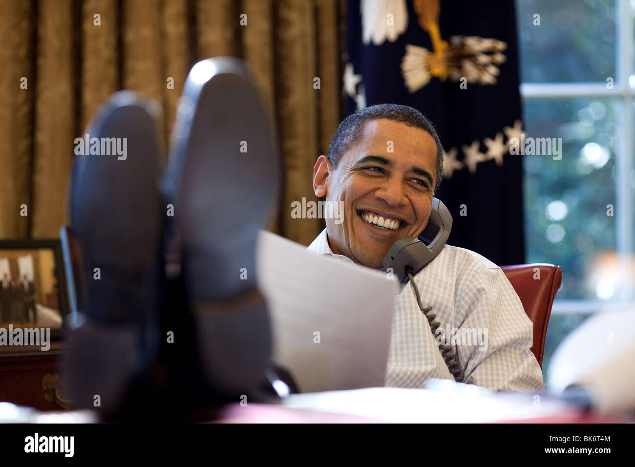 Präsident Barack Obama lächelt während des Gesprächs am Telefon im Oval Office mit russischen Präsidenten Dmitry Medvedev Stockfoto