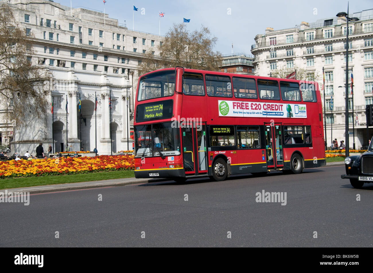 Ein London-Bus fährt der Marble Arch und eine bunte Blumen im Zentrum von London Stockfoto