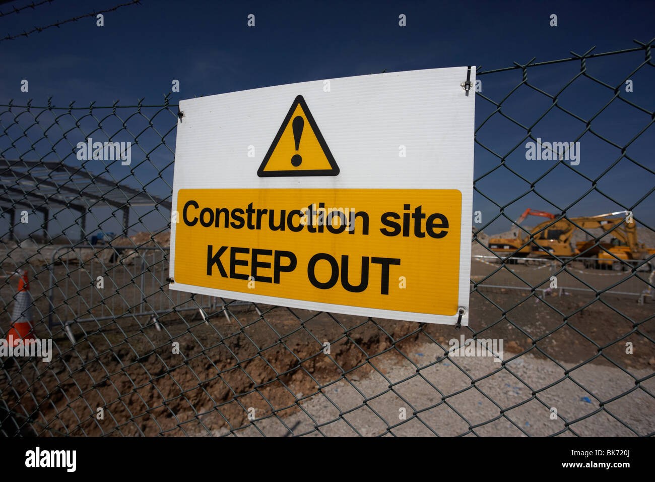 Baustelle fernzuhalten Schild an einem Kettenglied Zaun rund um eine Neuentwicklung, die Baustelle mit schwerem Gerät Stockfoto