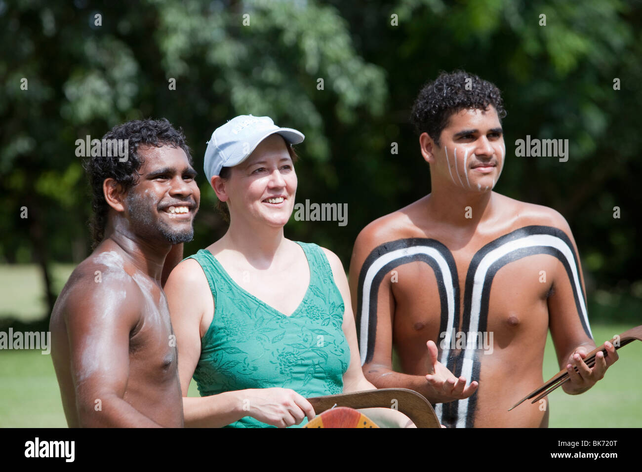 Touristen posieren für Fotos mit Aborigines mit Bumerang im Tjapukai Aboriginal Park in der Nähe von Cairns, Queensland, Australien. Stockfoto