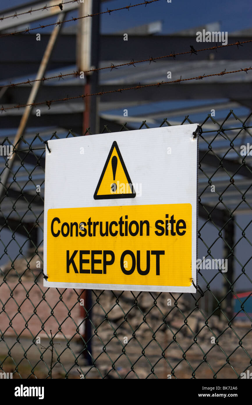 Baustelle fernzuhalten Schild an einem Kettenglied Zaun rund um eine Neuentwicklung, die Baustelle mit alten Fabrik Stockfoto