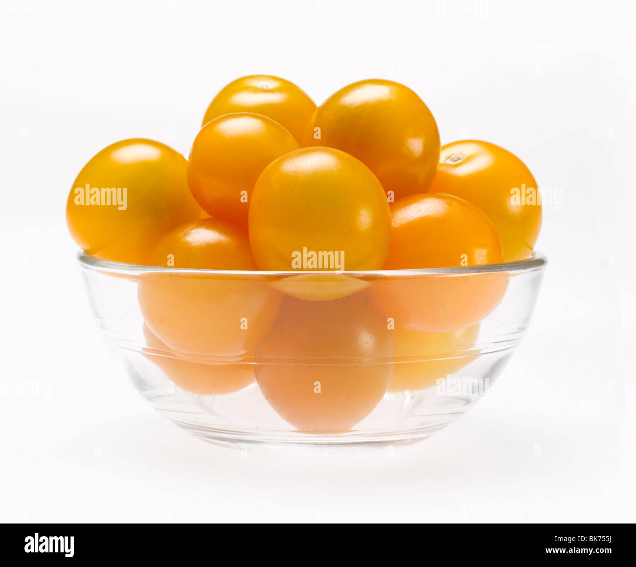 gelbe Cherry-Tomaten in Glasschüssel auf weißem Hintergrund Stockfoto