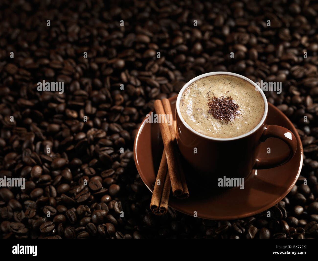 Tasse Kaffee Latte mit Schokolade und Zimt auf Kaffeebohnen Hintergrund Stockfoto