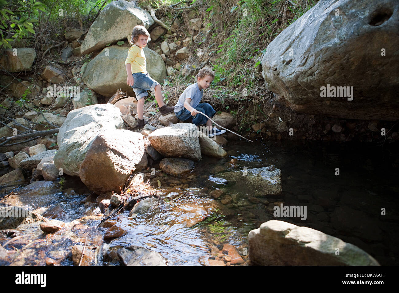 Jungs auf Felsen Fluss Stockfoto