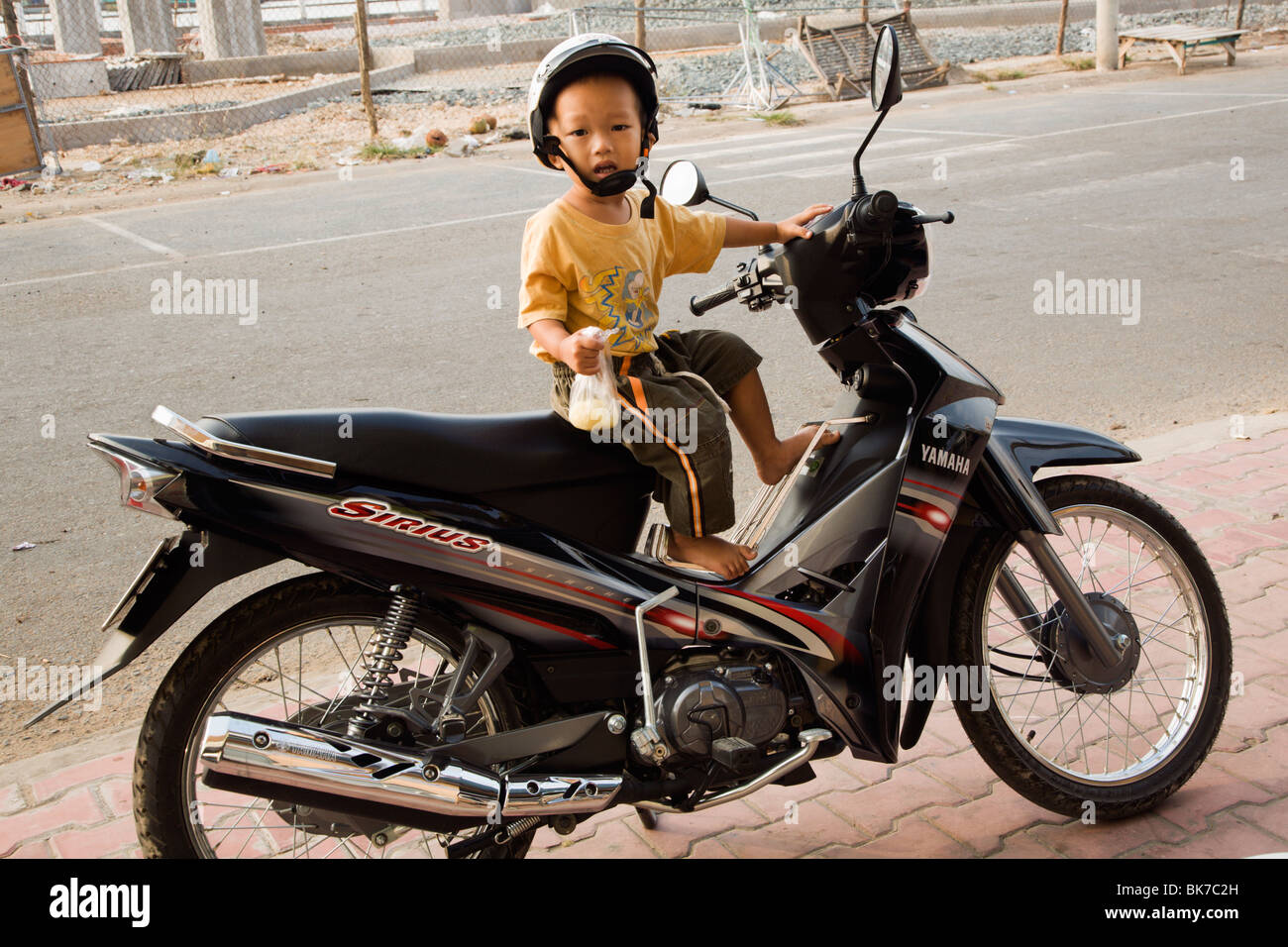 Sehr junge Motorbikedriver warten auf Mama von dem täglichen Markt in Ha Tien Mekong Delta Vietnam Stockfoto