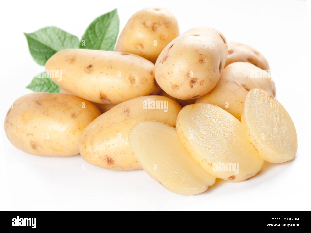 Gelbe Kartoffeln mit Blättern auf weißem Hintergrund Stockfoto