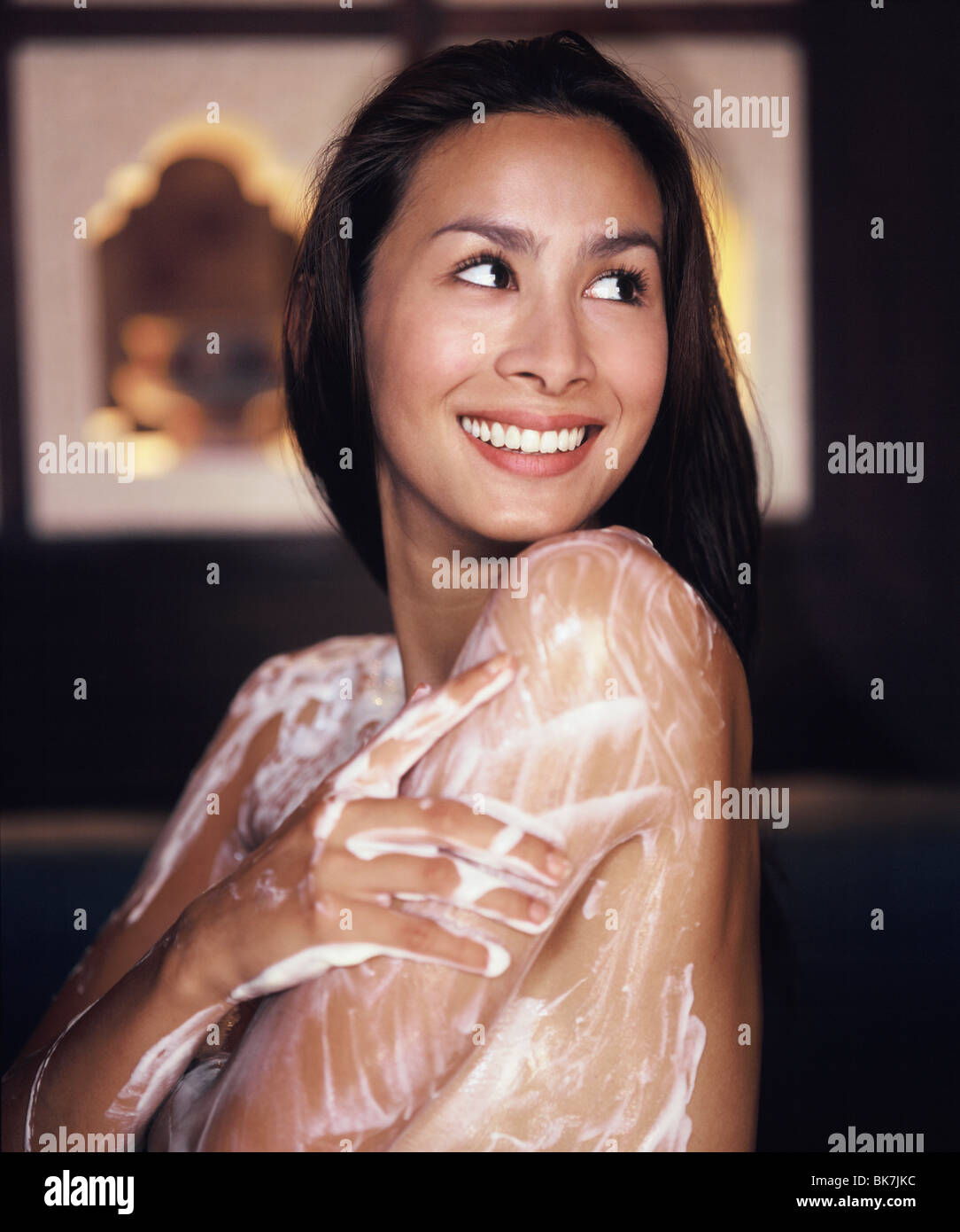 Junge Frau mit Körper bedeckt in Joghurt Peeling Stockfoto