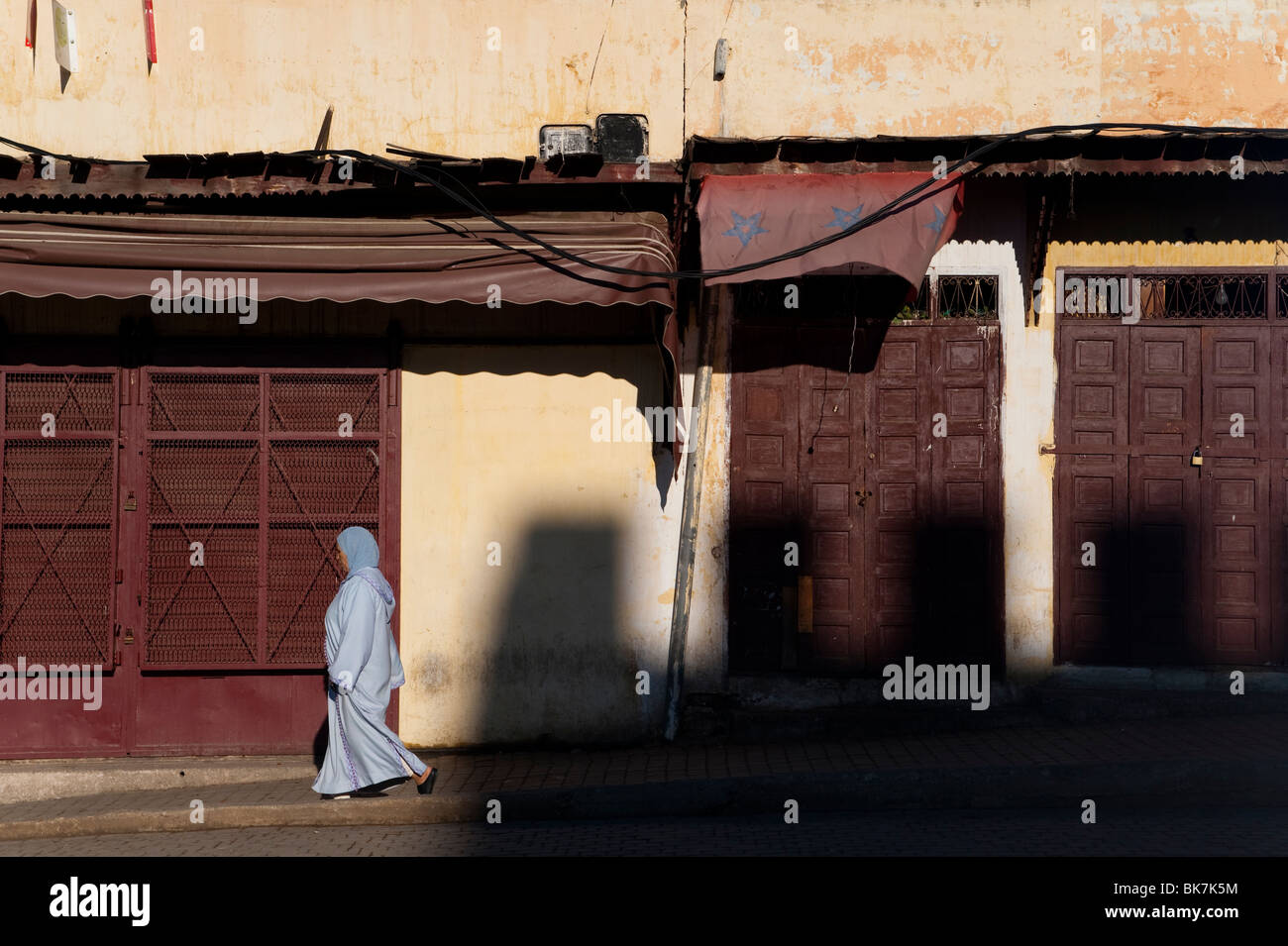 Frau zu Fuß gegenüber der Medina Zinnen, Meknès, Marokko. Stockfoto