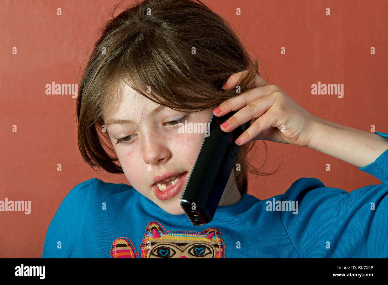 6 - Jahre altes Mädchen im Chat mit einem Freund auf ein schnurloses Telefon Stockfoto