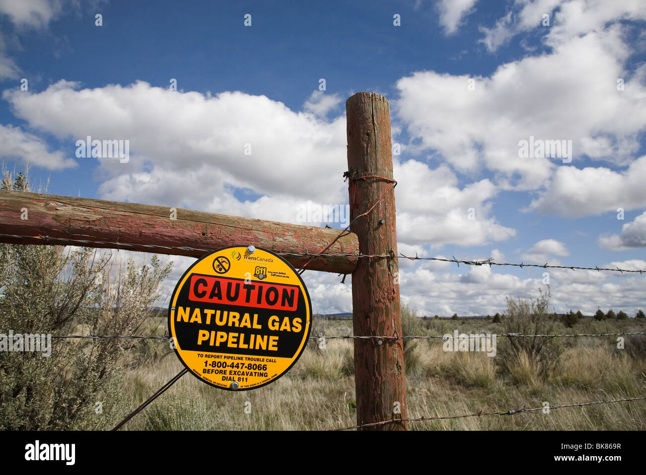 Ein Vorsicht Schild an einem Stacheldrahtzaun warnt Besucher über eine Trans Canada Natural Gas-Pipeline, begraben in der Nähe, in der Nähe von Madras, Oregon. Stockfoto