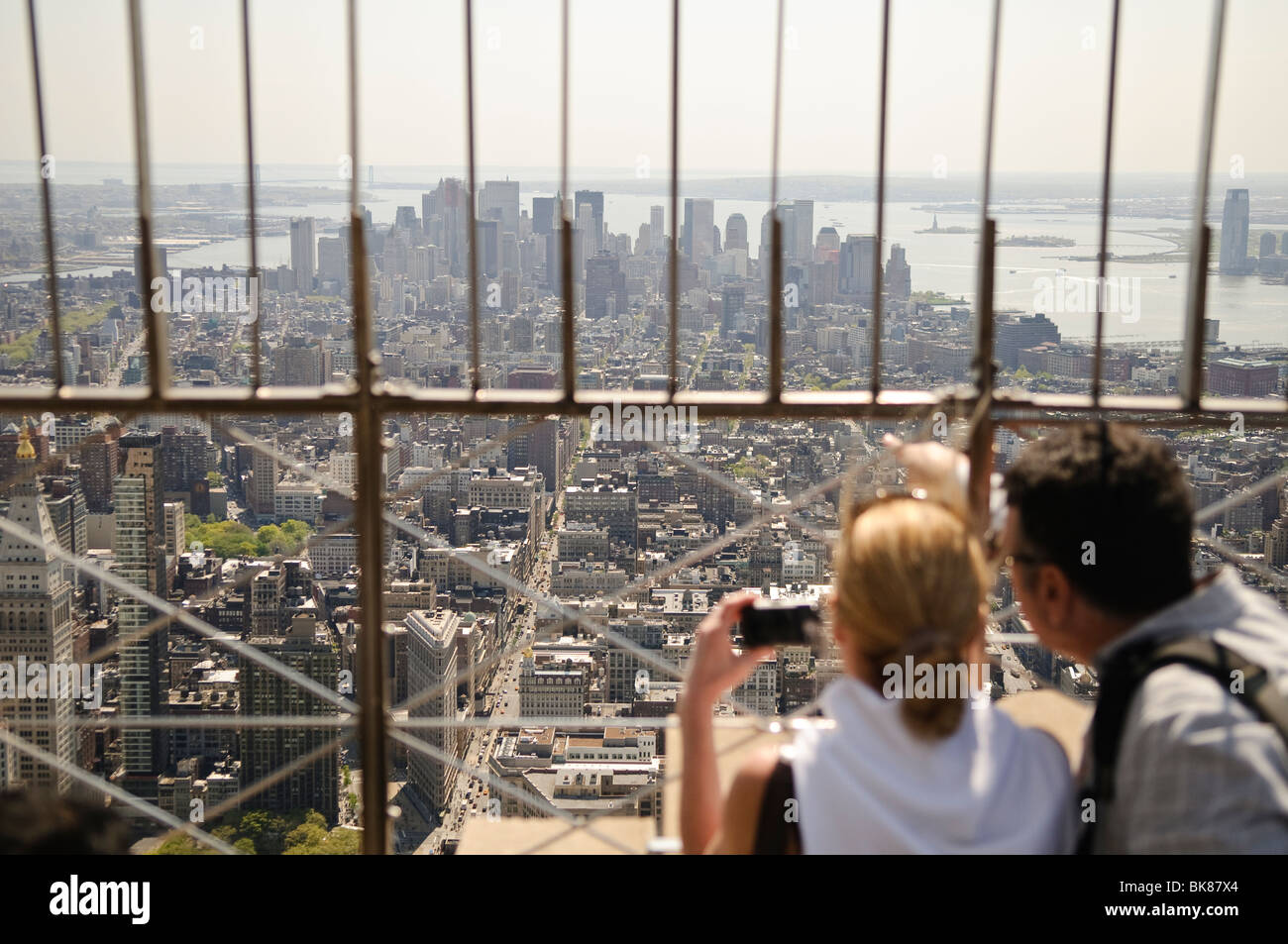 NEW YORK, NY-Touristen bewundern Sie die Aussicht von der Spitze des Empire State Building in New York City an einem klaren Frühlingstag. Stockfoto