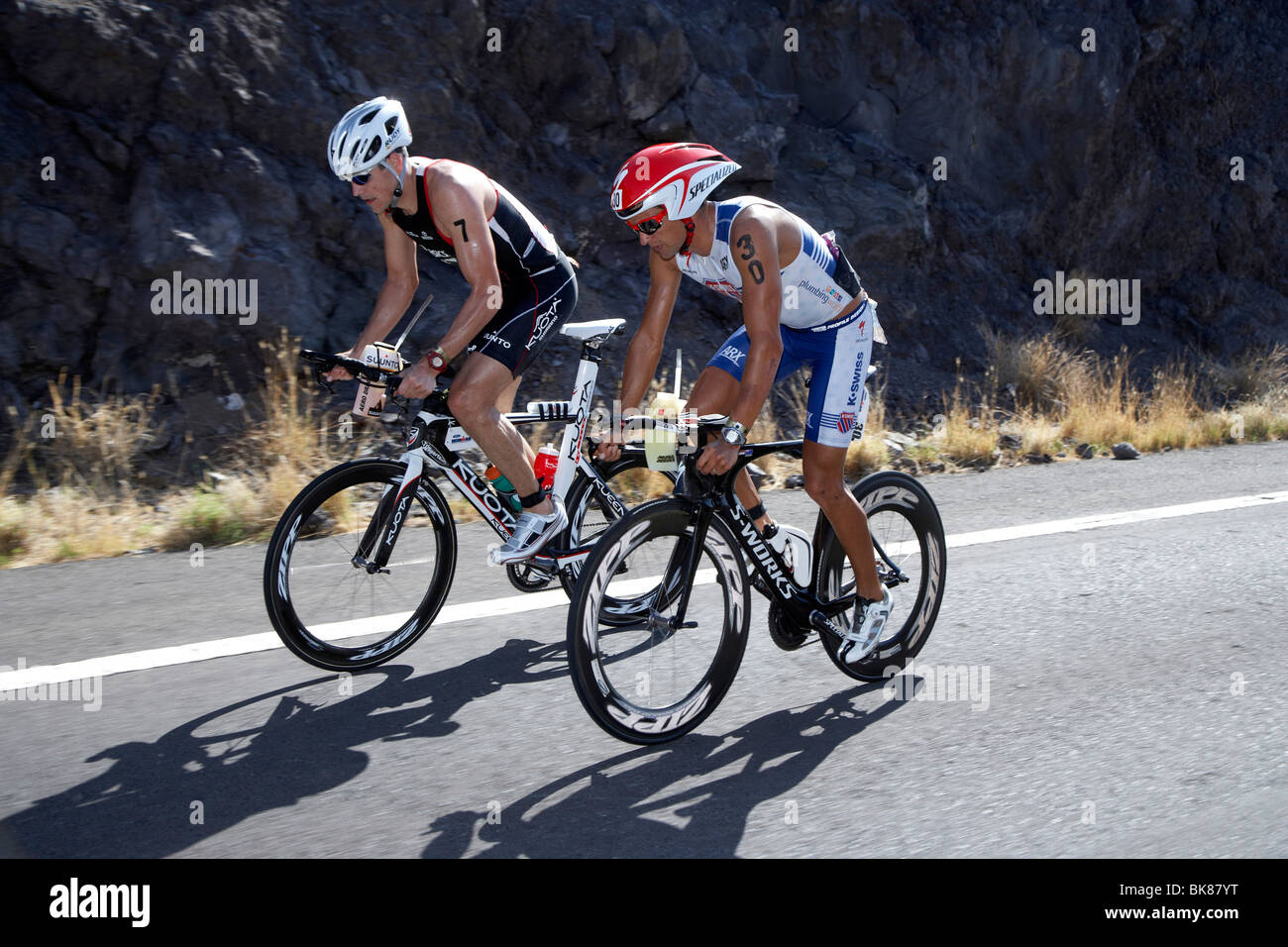 Die New Zealand Profi-Triathletin Terenzo Bozzone, Recht, und die Amerikaner Andy Potts auf der Radstrecke des Ironman Triathlon Stockfoto