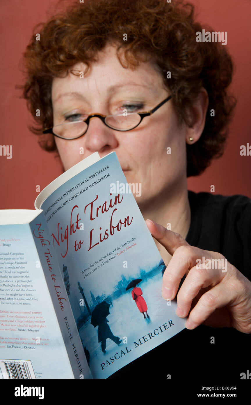 Mittlere gealterte Frau liest Roman, Nachtzug nach Lissabon Stockfoto