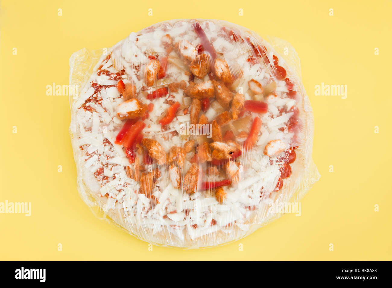 Großen gefrorenen Huhn, Paprika und Mozzarella-Käse-Pizza in Cellophan verpackt Stockfoto