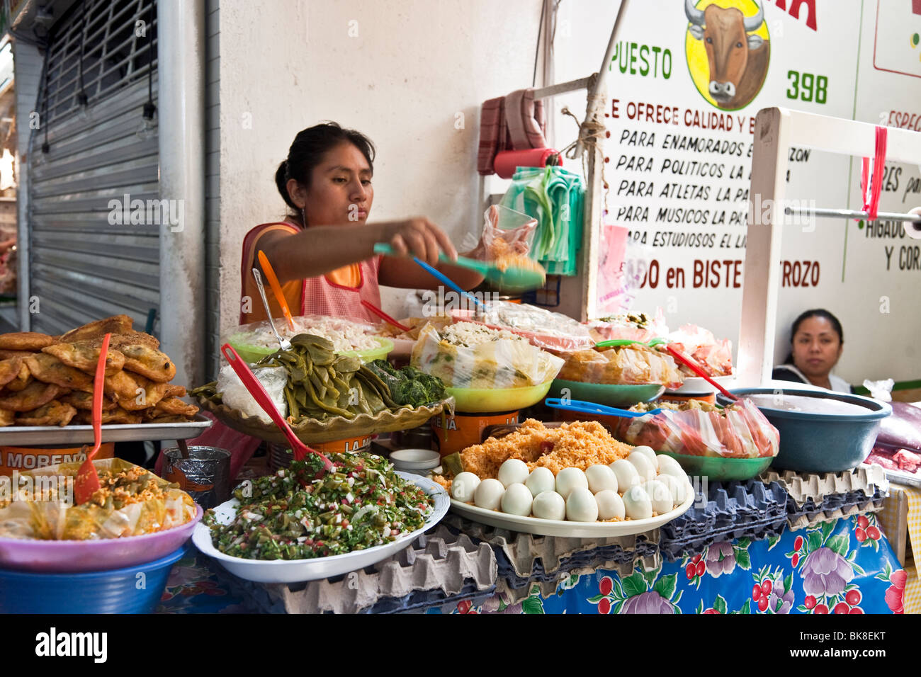 Frau dishing kalten gekochten Reis aus verführerische Auswahl an vorbereiteten Typ Delikatessen in Benito Juarez Markt Oaxaca Mexico Stockfoto