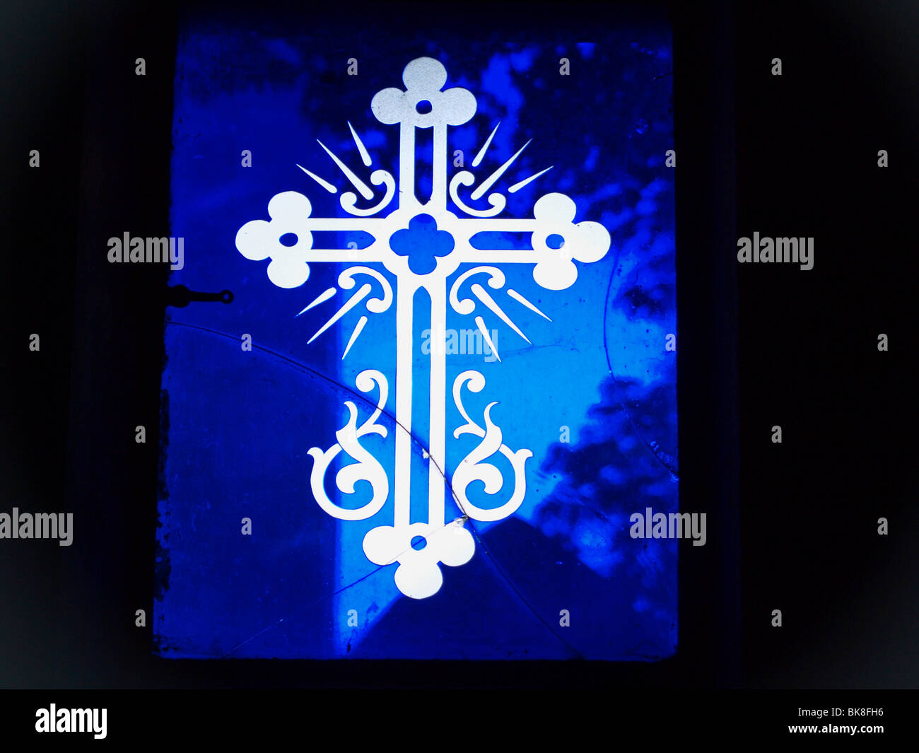 Geschliffenes Glas Kreuz auf blauem Glas Stockfoto