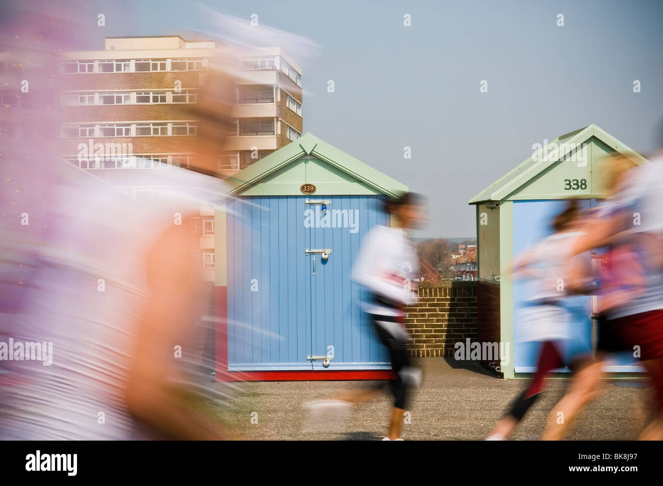 Verschwommene Läufer laufen vorbei an Strandhütten in der ersten Brighton Marathon April 2010, Hove, East Sussex, UK Stockfoto