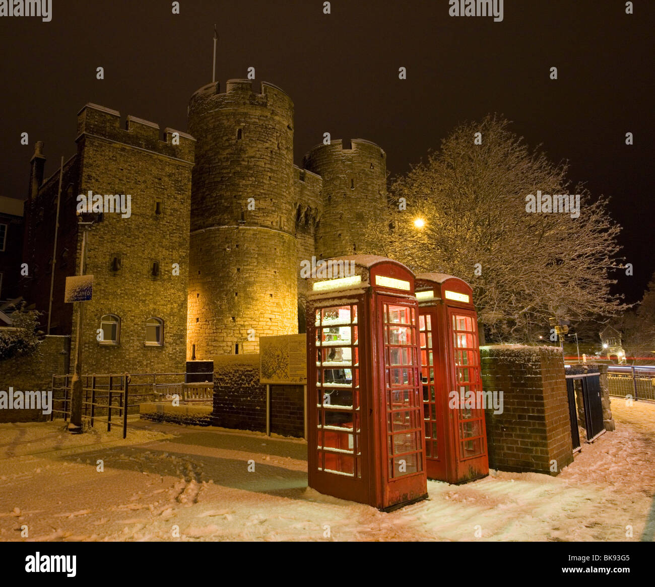 Telefonzellen und Westgate Türme mit Schnee in Canterbury, Kent, UK bedeckt. Stockfoto