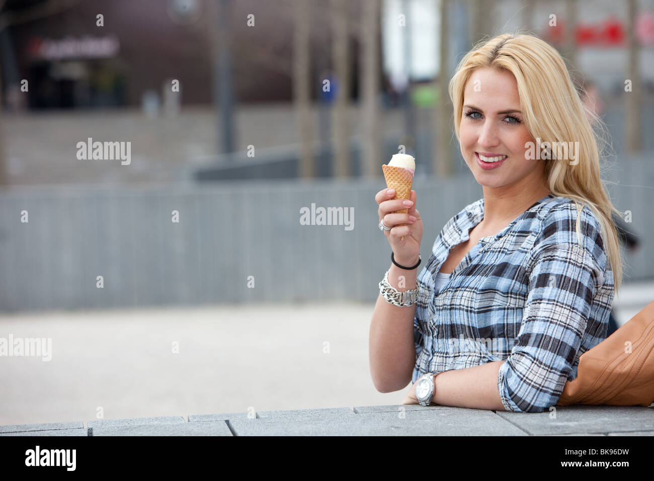 Schöne junge Mädchen stehen im Freien und ein Eis essen Stockfoto