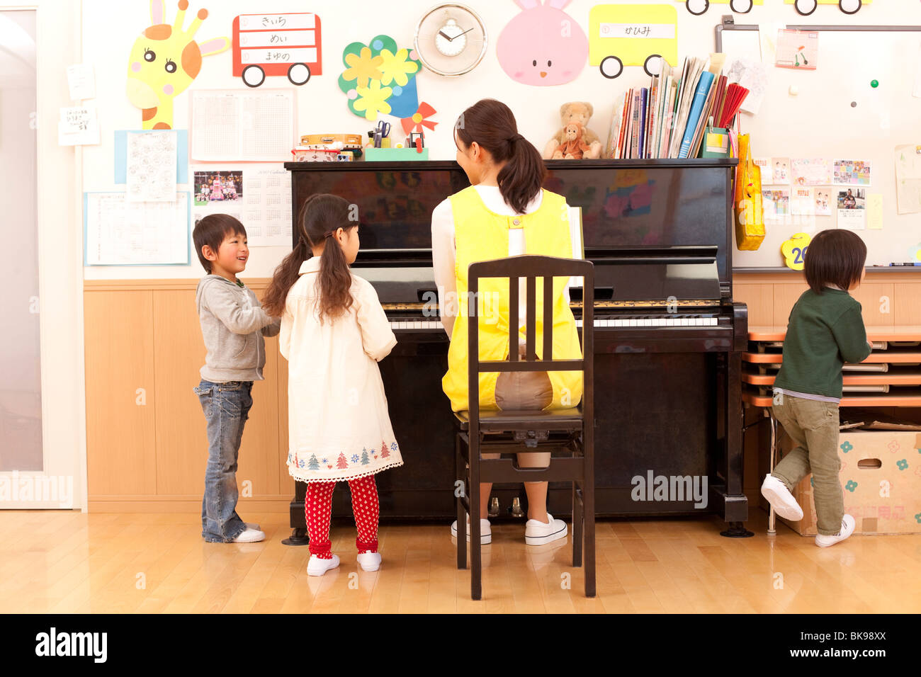 Kindergärtnerin, Klavierspielen mit Kindern Stockfoto