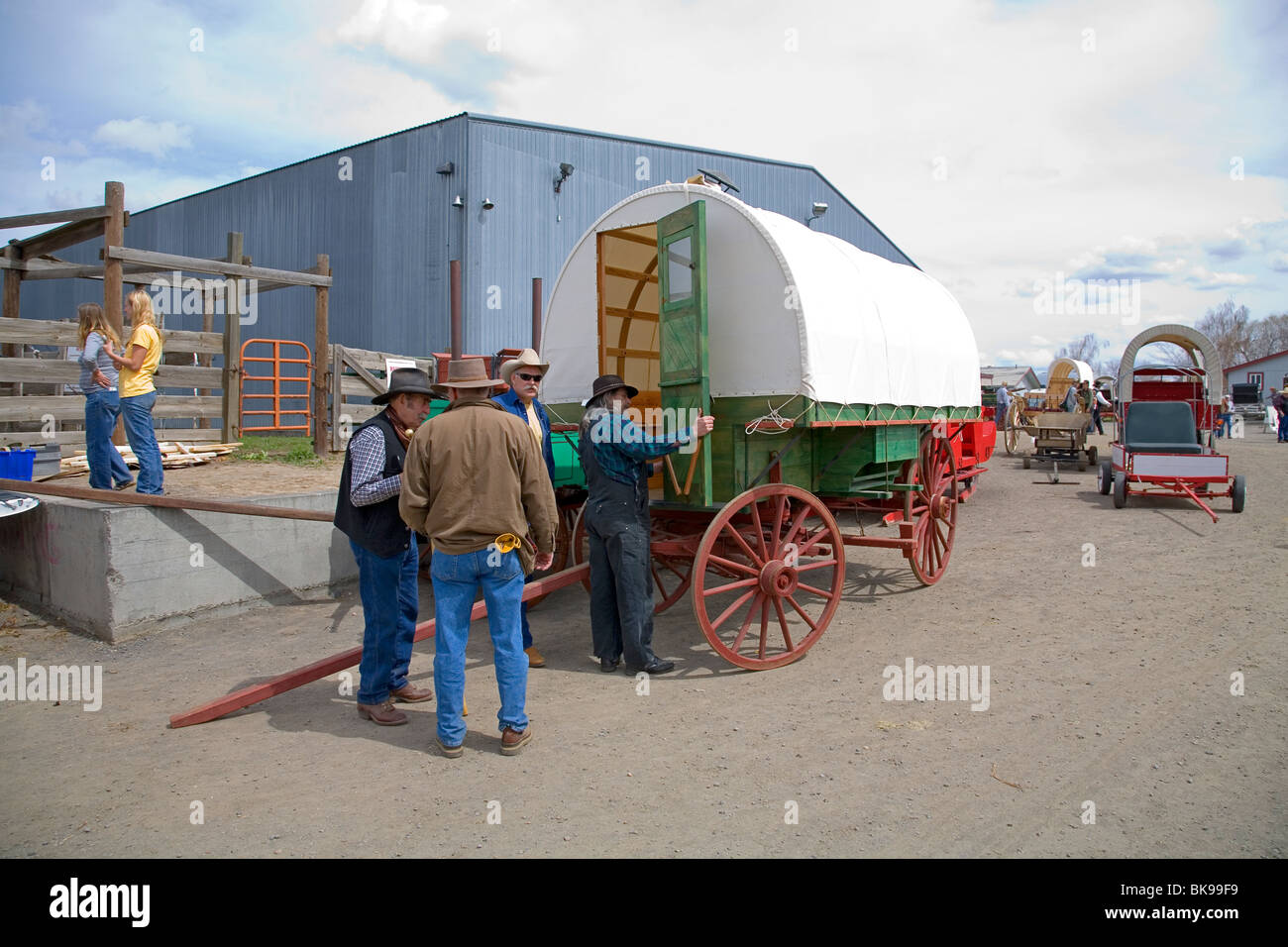 Ältere Cowboys und Besucher untersuchen einen baskischen Schäfer Wagen auf einer Kirmes in Madres, Oregon Stockfoto