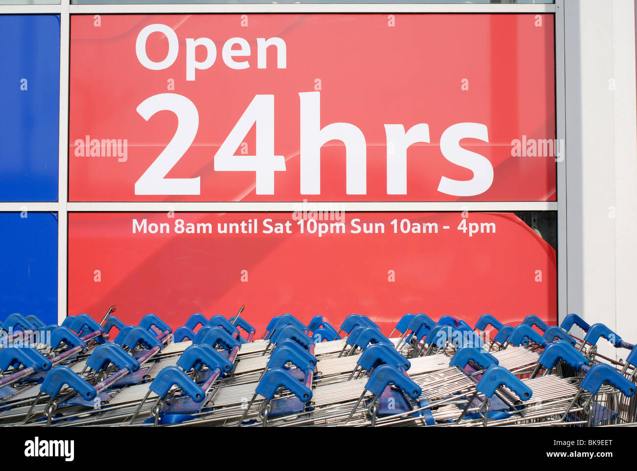Einkaufswagen außerhalb einer offen 24 Stunden-Zeichen auf einen Tesco-Supermarkt. Stockfoto
