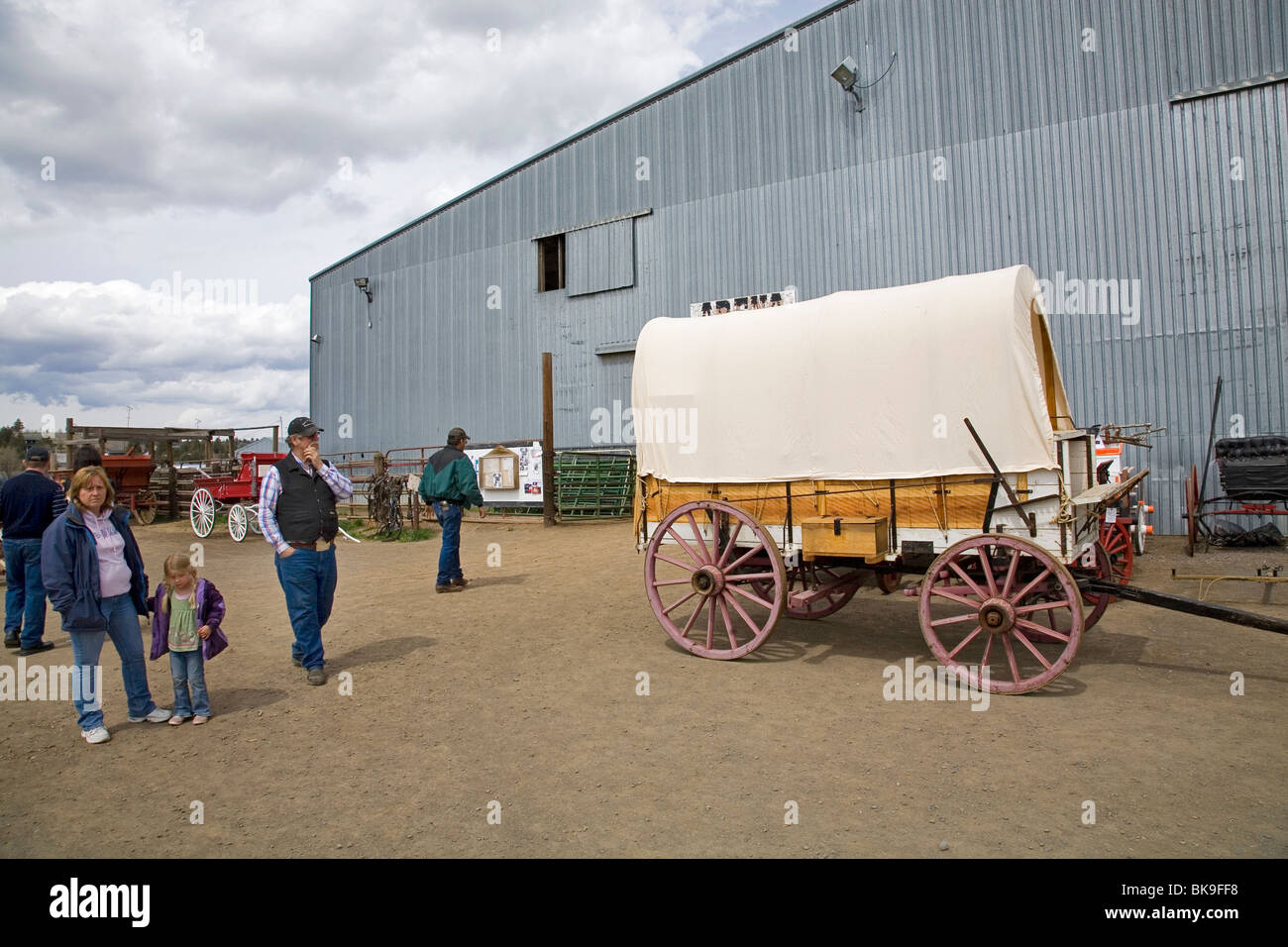Besucher zu untersuchen, eine Anzeige der alten und umgebaute Pferd gezeichneten Wagen auf einer Kirmes in Madras, Oregon Stockfoto