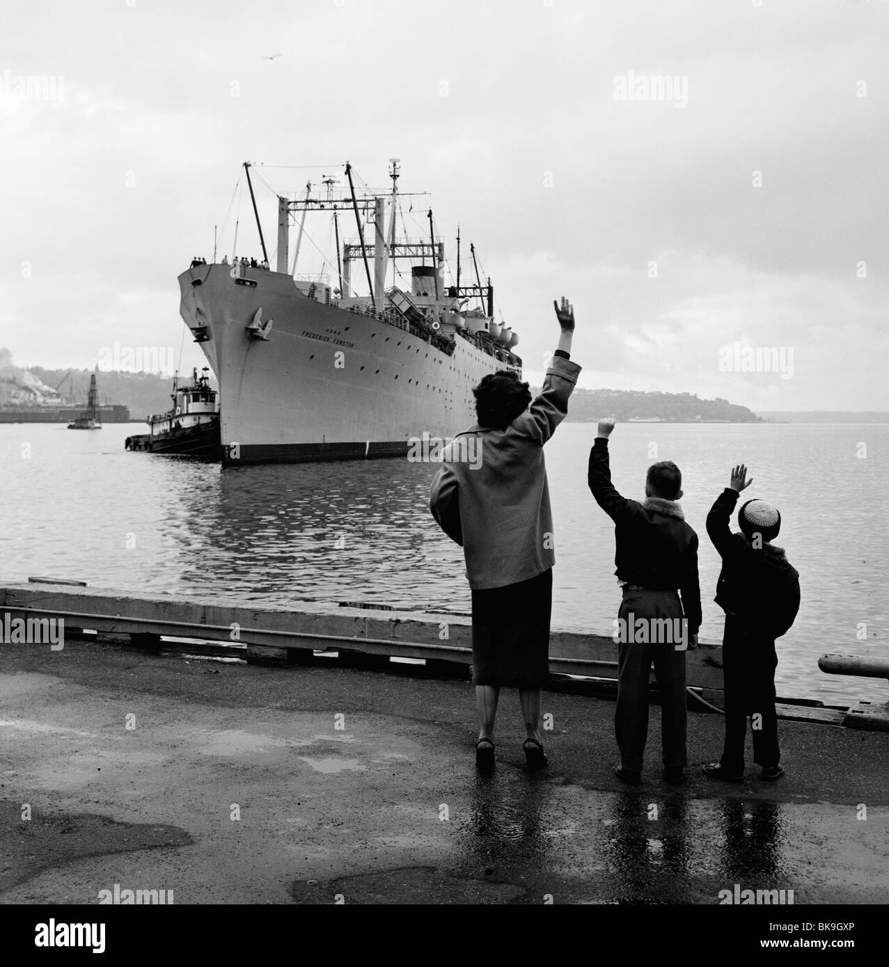 Mutter mit zwei Kindern winken an ausgetretene Dampfschiff Stockfoto