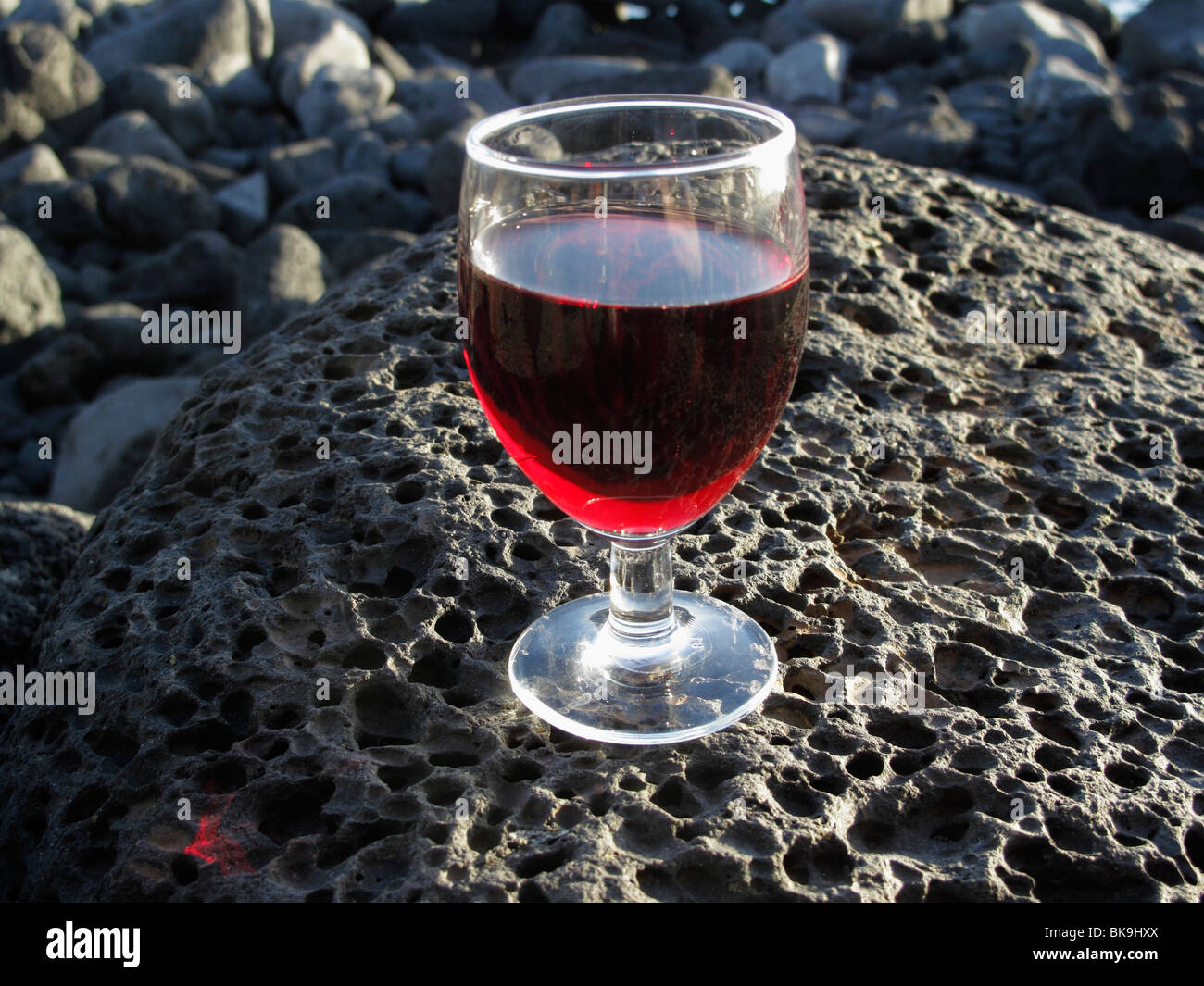 Glas Rotwein auf Lavastein, La Palma, Kanarische Inseln, Spanien Stockfoto