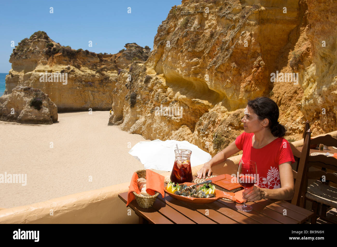 Frau im Restaurant am Praia Dos Tres Irmãos in der Nähe von Alvor, Algarve, Portugal, Europa Stockfoto