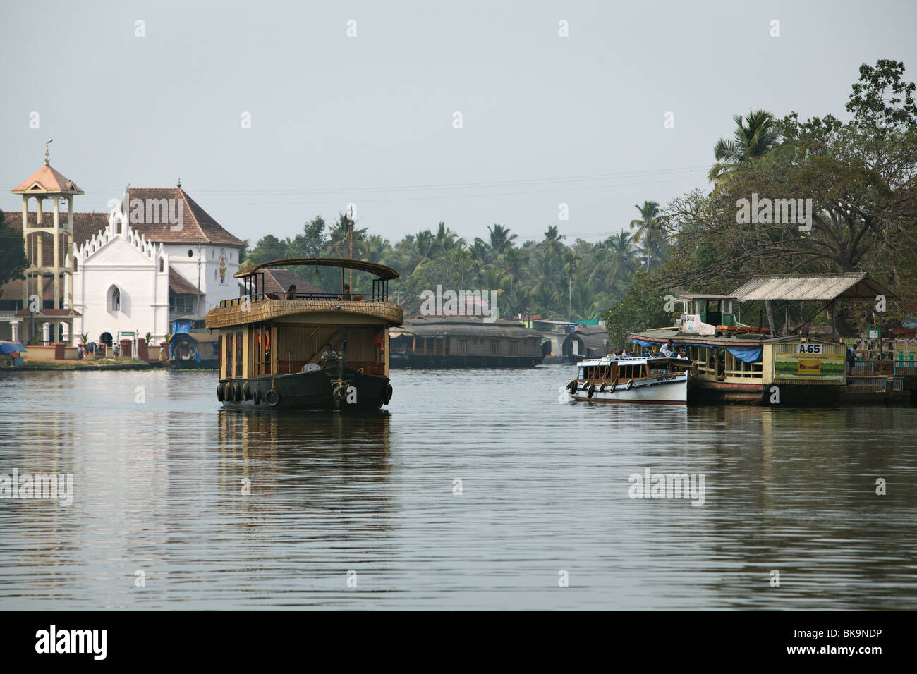 Hausboot vorbei ein Dorf mit einer christlichen Kirche in Backwaters von Kerala, Indien. Stockfoto