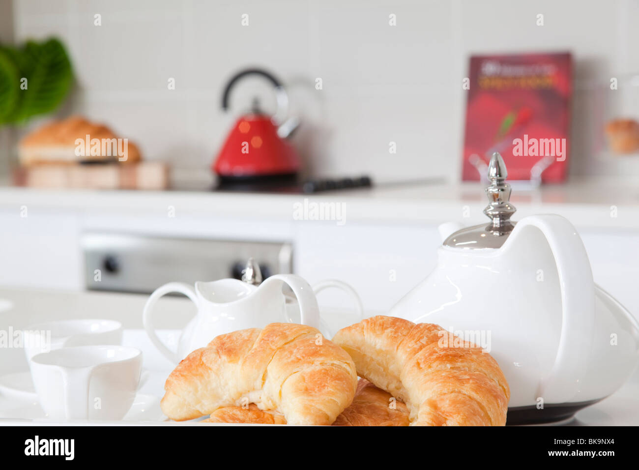 Frühstück in der modernen Küche mit Croissants und Kaffee Stockfoto