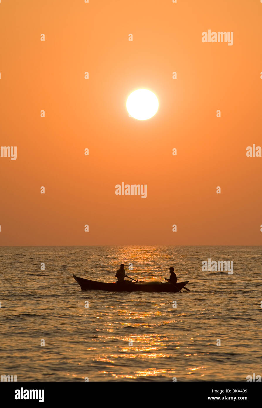 Zwei Personen in einem Boot im Meer bei Sonnenuntergang Stockfoto