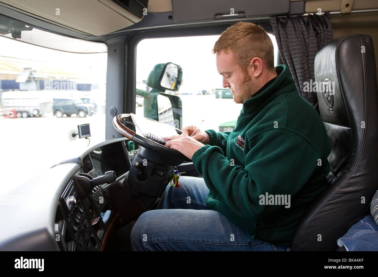 Ein LKW-Fahrer ändern einer Kontrollgerätkarte in seiner Kabine Stockfoto