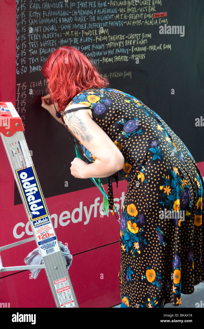 Eine Melbourne International Comedy Festival-Veranstalter schreibt das tägliche Programm außerhalb Melbourne Town Hall Stockfoto